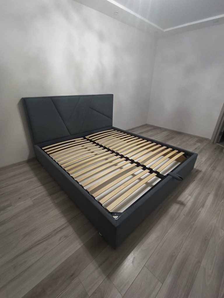 łóżko tapicerowane z materacem w małej sypialni