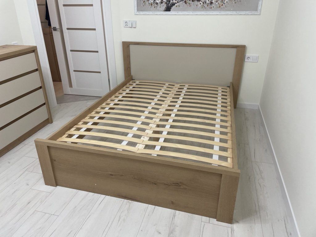 drewniane łóżko w jasnej sypialni w mieszkaniu