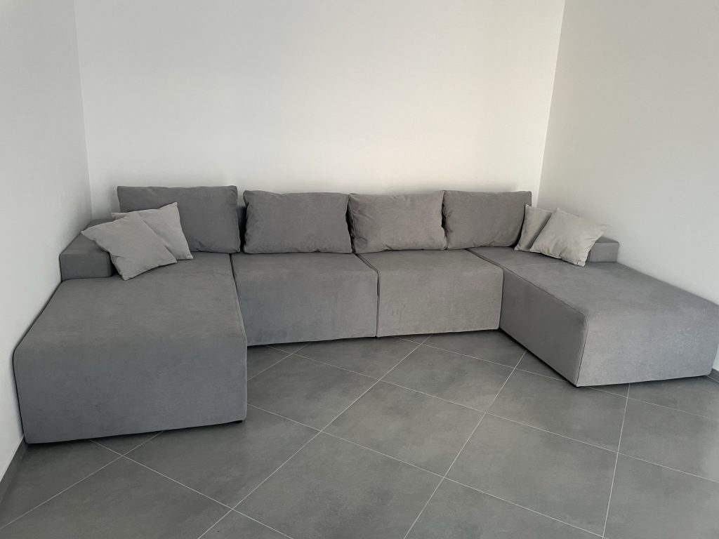 duza sofa z funkcja spania w jednopokojowym mieszkaniu