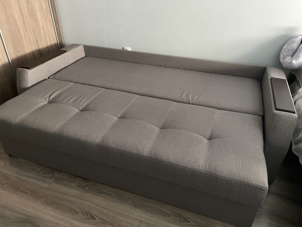 szara sofa tapicerowana z pojemnikiem na posciel do mieszkania na wynajem