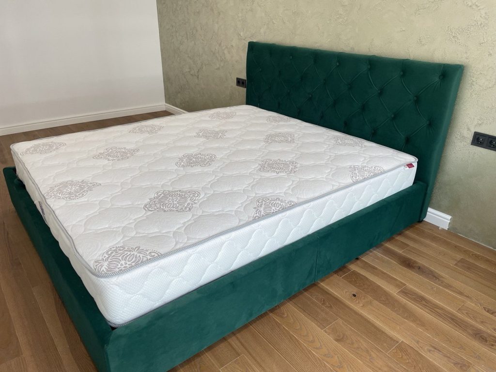 pikowany zagłówek zielonego łóżka tapicerowanego